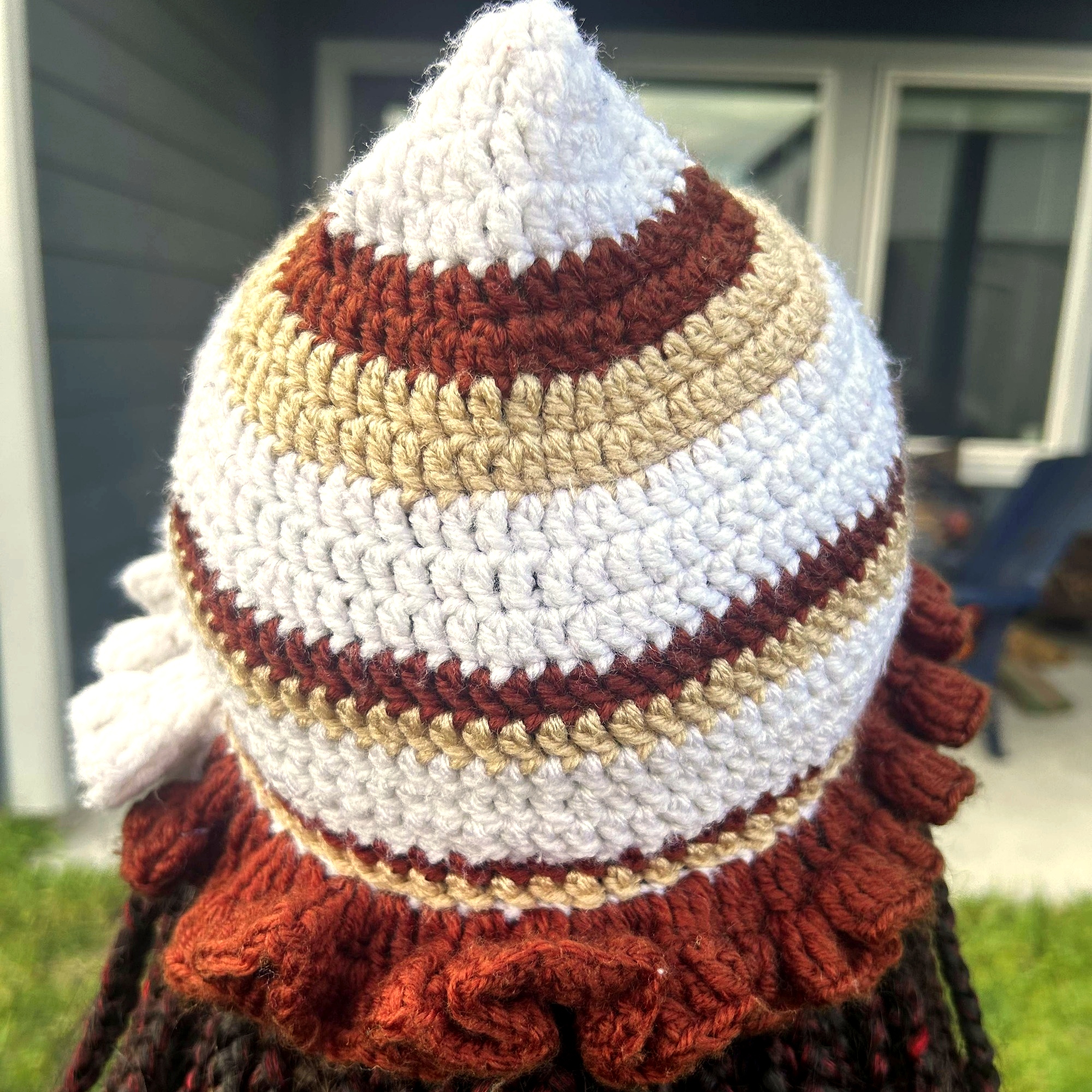 Rear view of handmade Jamaican cream tan and rust striped crochet hat with ruffled brim