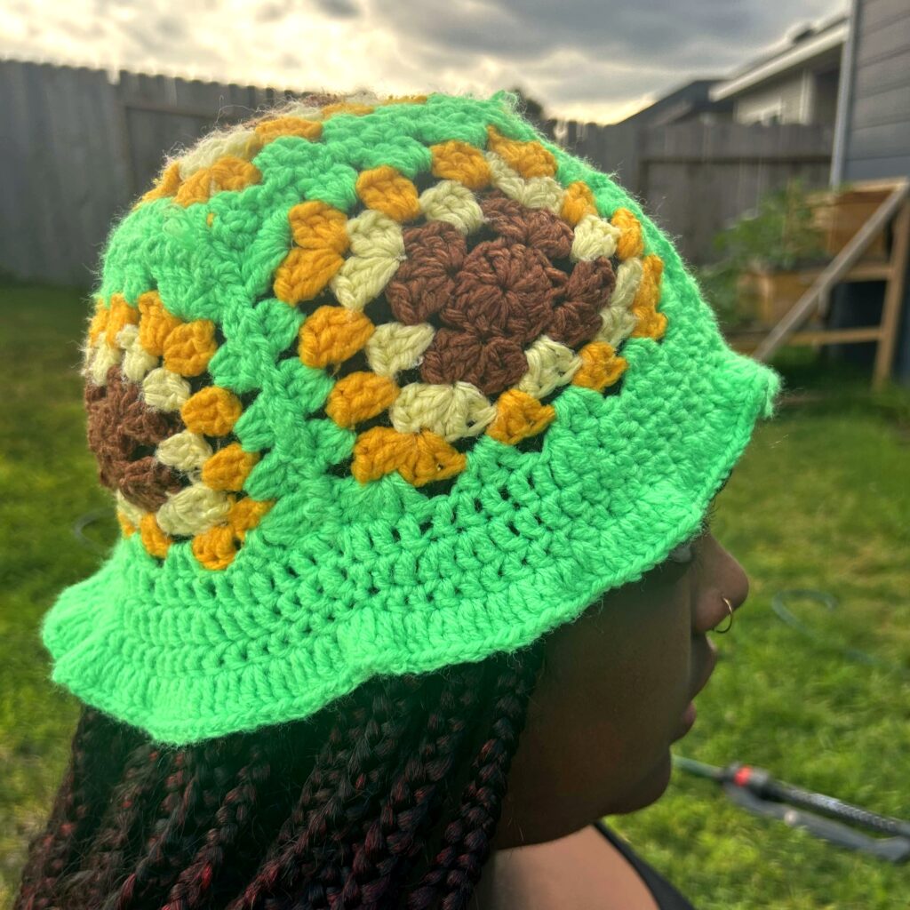 Handmade Jamaican green granny-stitch crochet bucket hat with brown cream and mustard-gold crown motifs