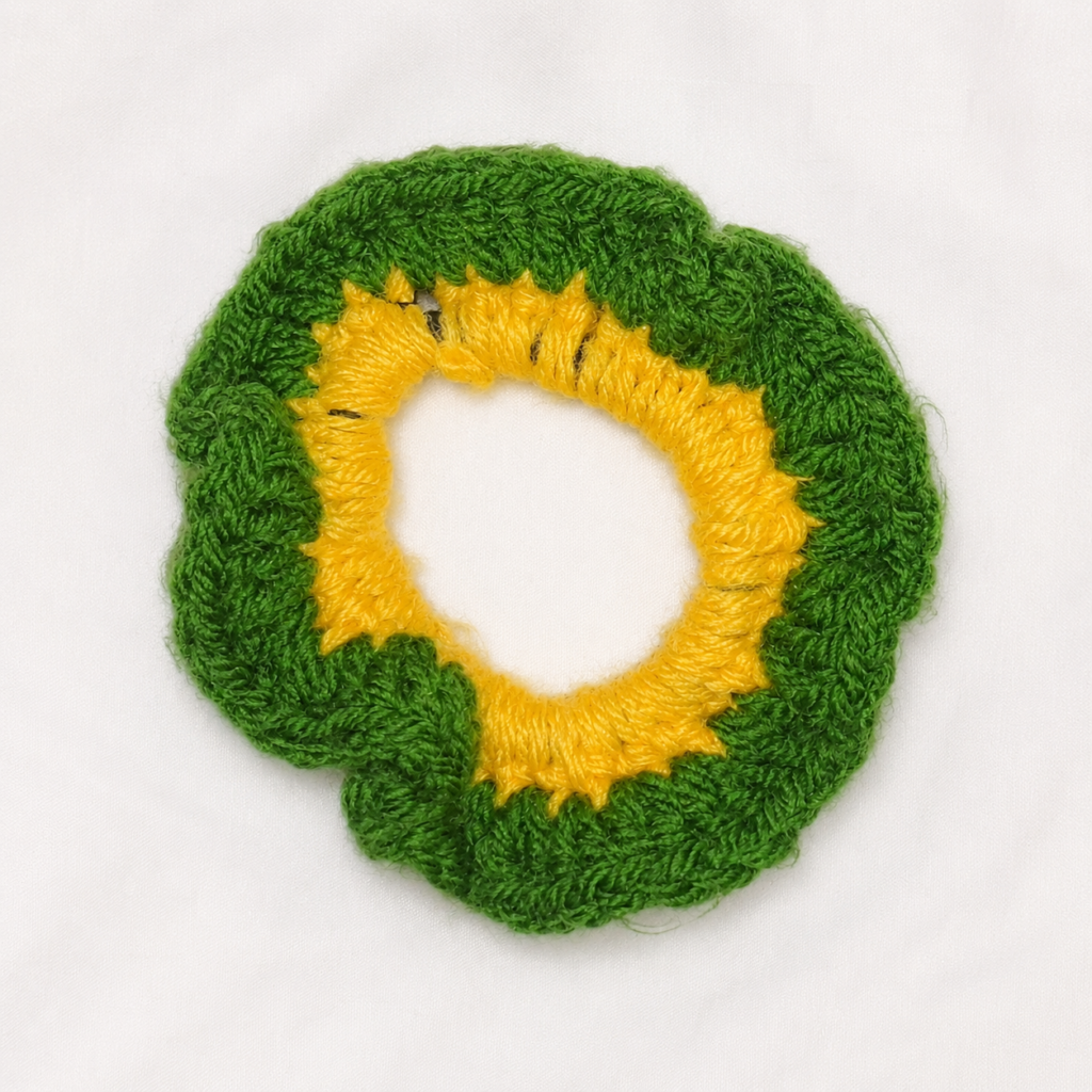 Handmade Jamaican green crochet scrunchie with yellow center on a clean white background