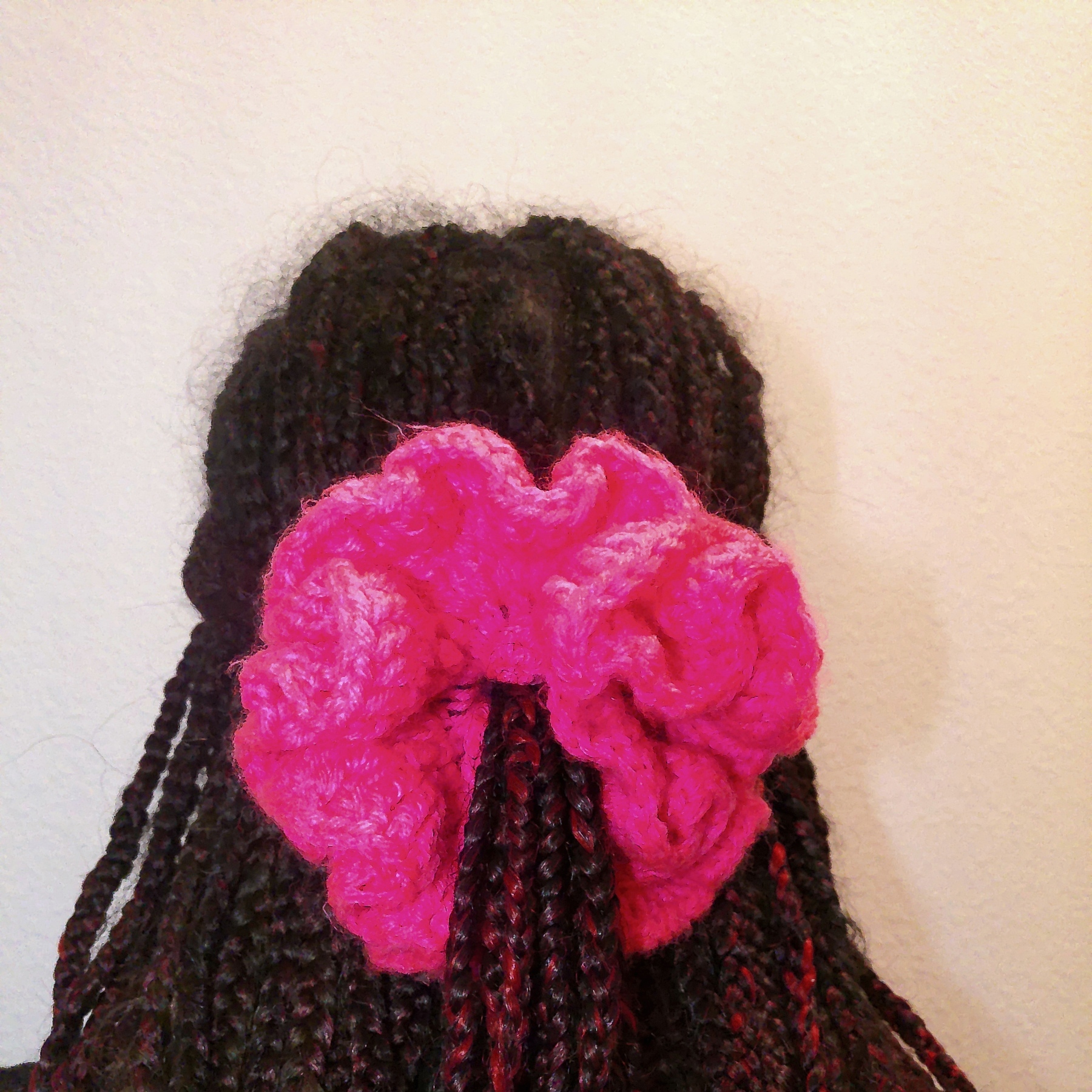 Handmade Jamaican hot-pink crochet scrunchie shown worn in hair