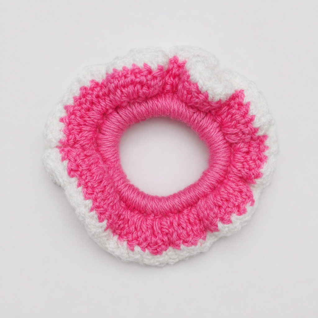 Handmade Jamaican hot-pink and white crochet scrunchie on a clean white background