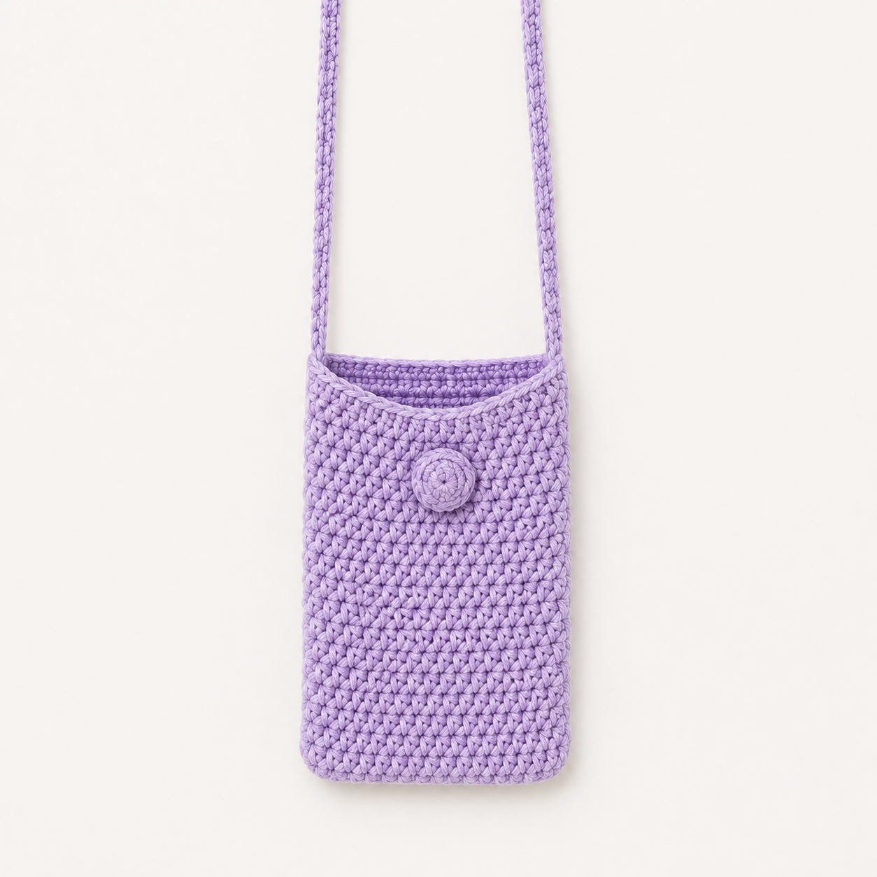 Handmade Jamaican lavender crochet shoulder phone pouch shown with a phone for scale