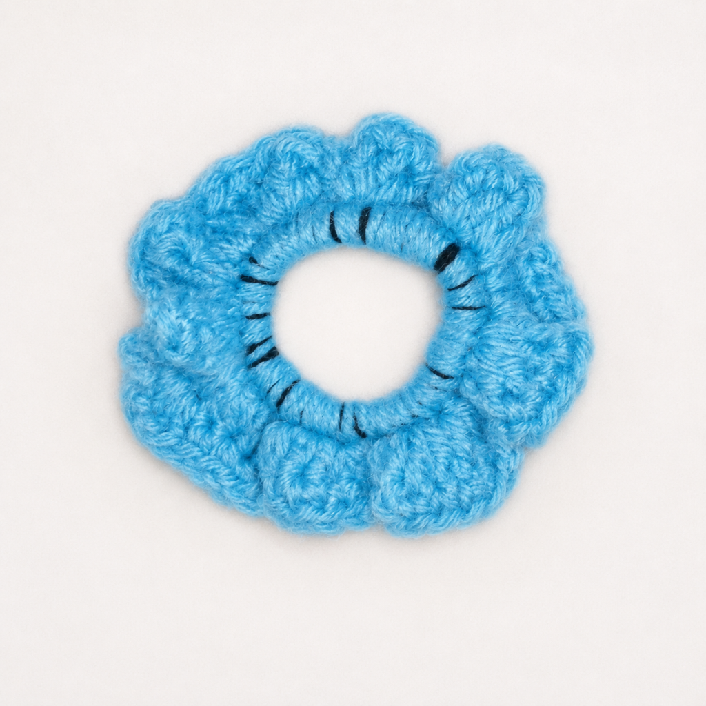 Handmade Jamaican light-blue crochet scrunchie on a clean white background