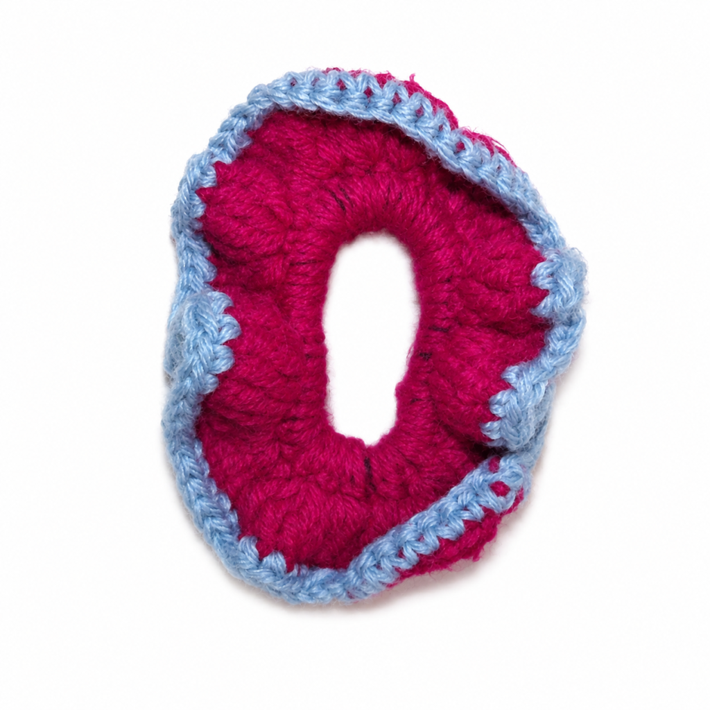 Handmade Jamaican magenta crochet scrunchie with light-blue edging on a clean white background