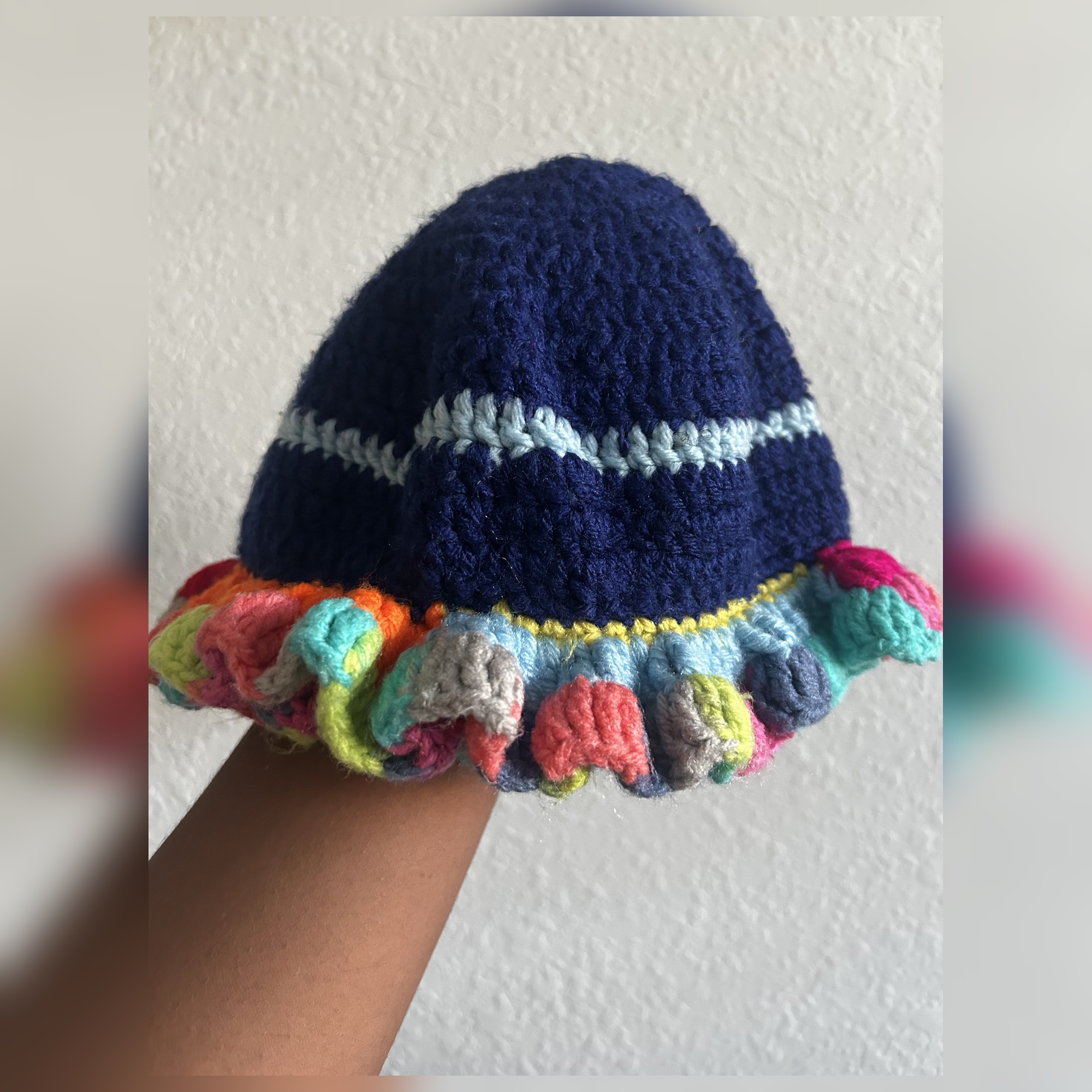 Handmade Jamaican navy blue crochet hat with light blue stripe and multicolor curled ruffle brim