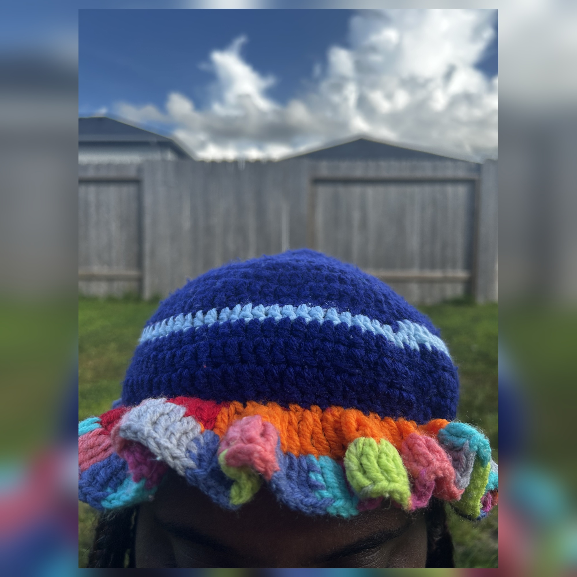 Front worn view of handmade Jamaican navy blue multicolor curled ruffle crochet hat