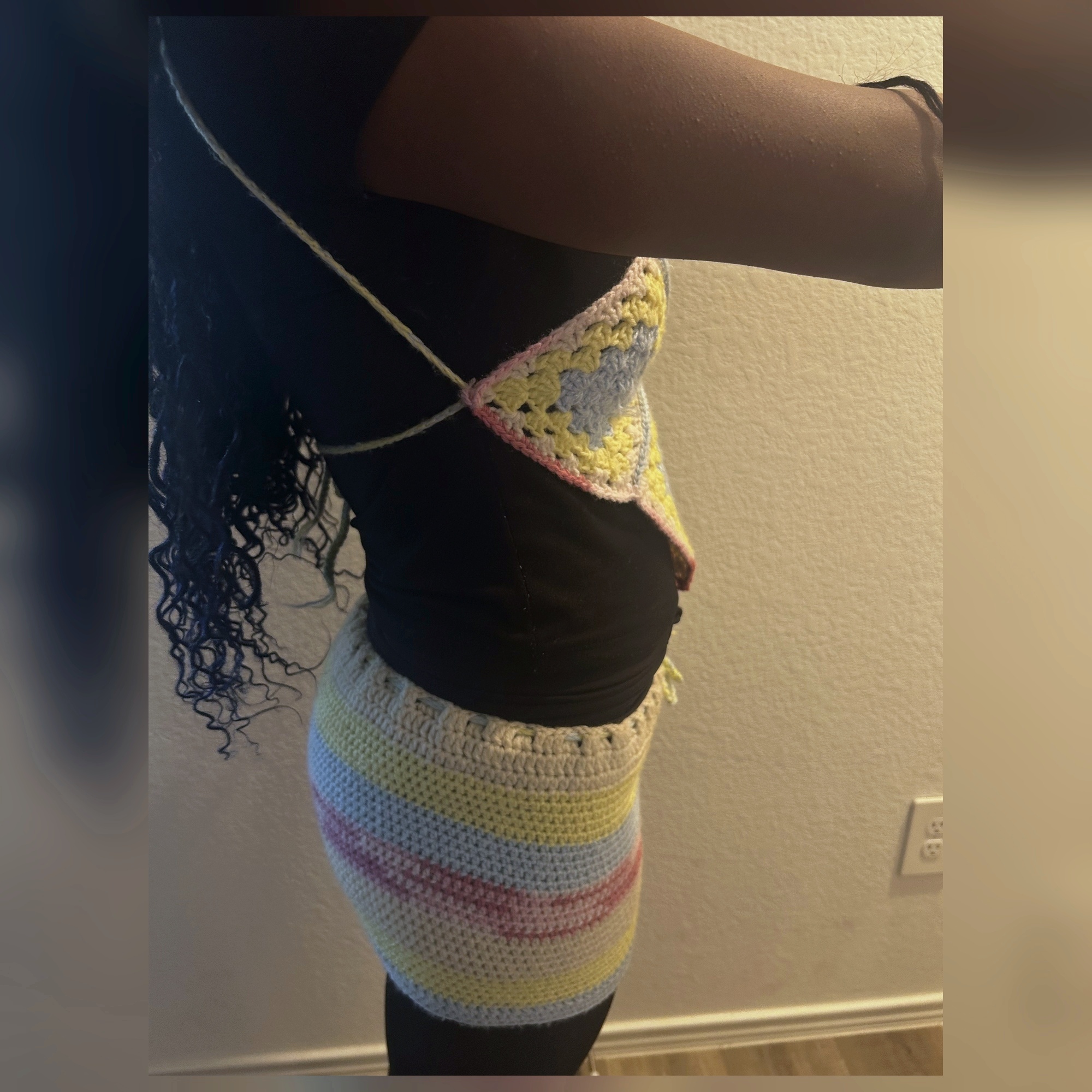 Side view of handmade Jamaican pastel granny-square crochet halter top and mini skirt set