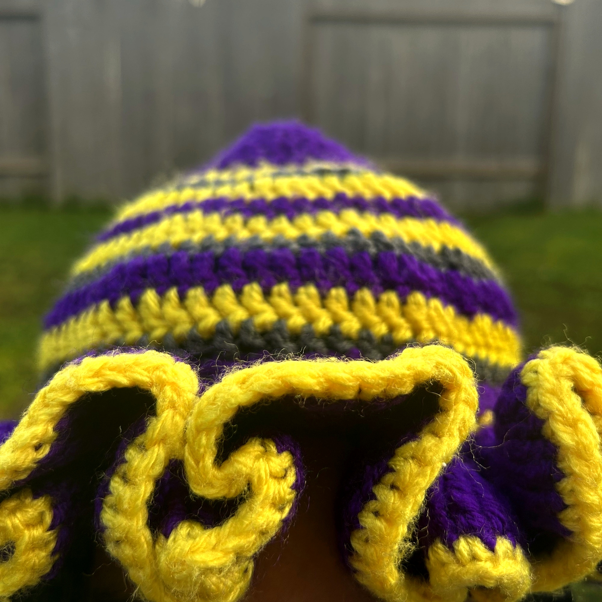 Close detail of purple and gold crochet ruffle brim on handmade Jamaican striped hat