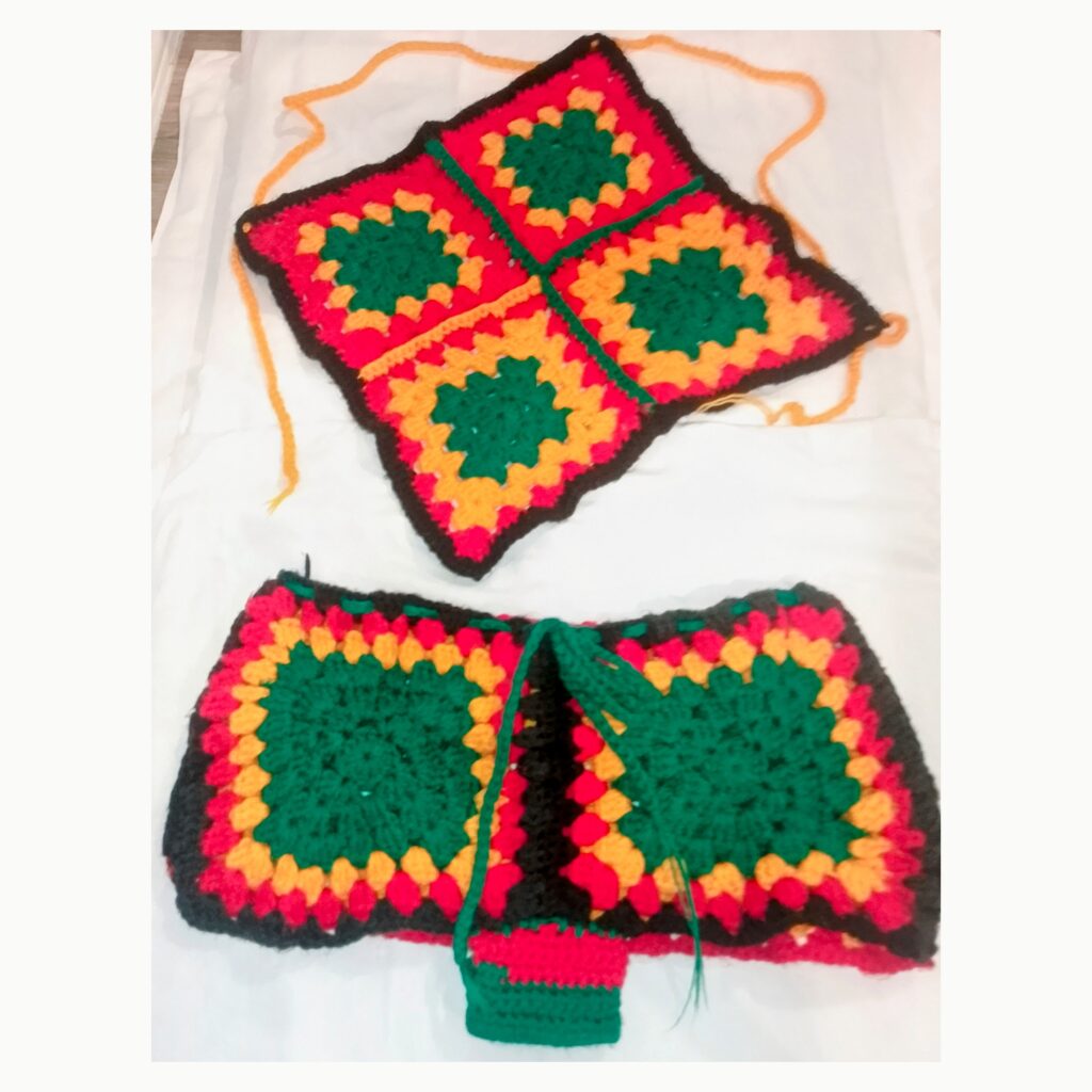 Handmade Jamaican red gold green and black granny-square crochet halter top and shorts two-piece set flat lay