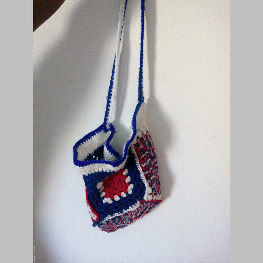 Handmade Jamaican red white and blue crochet shoulder bag shown as the featured product view