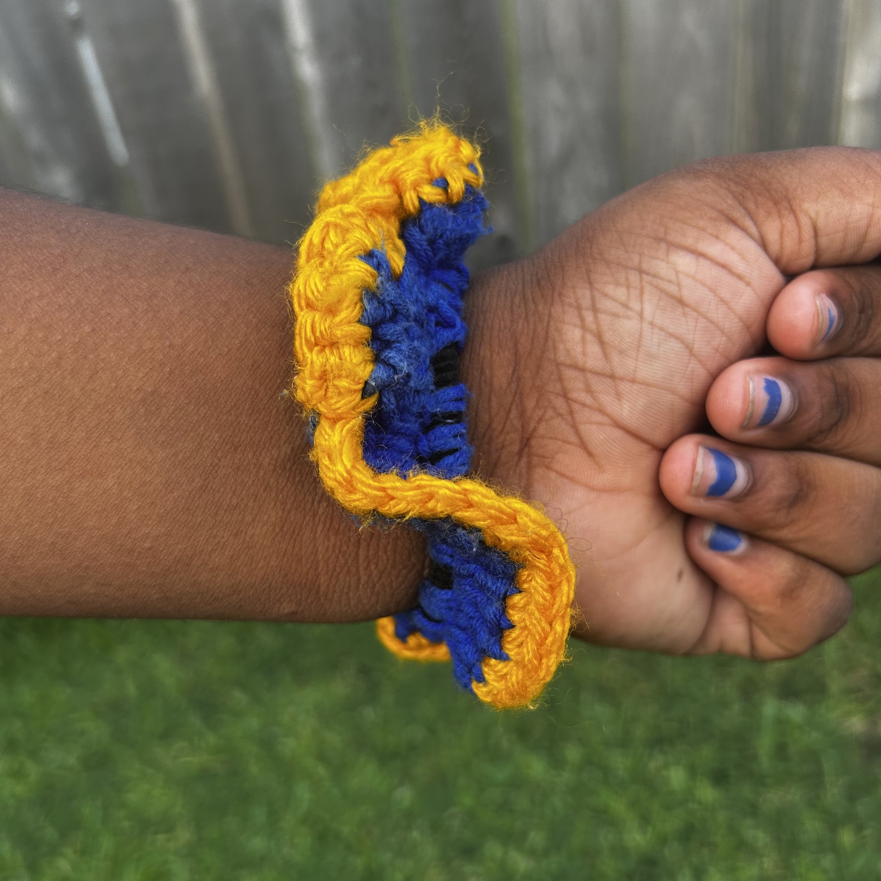 Close detail of handmade Jamaican royal-blue and golden-yellow crochet scrunchie