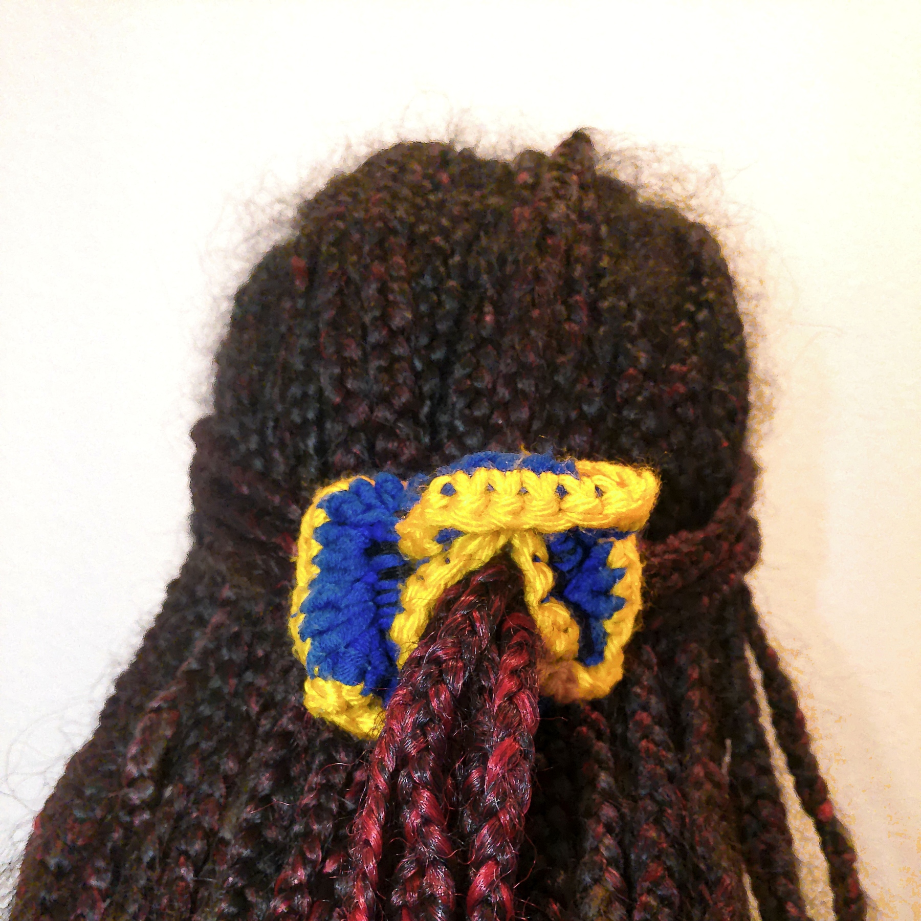 Handmade Jamaican royal-blue and golden-yellow crochet scrunchie shown worn in hair